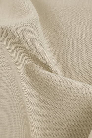 Cotton double knit fabric close-up with folded drape detail for lightweight casualwear and comfortable layering garments.